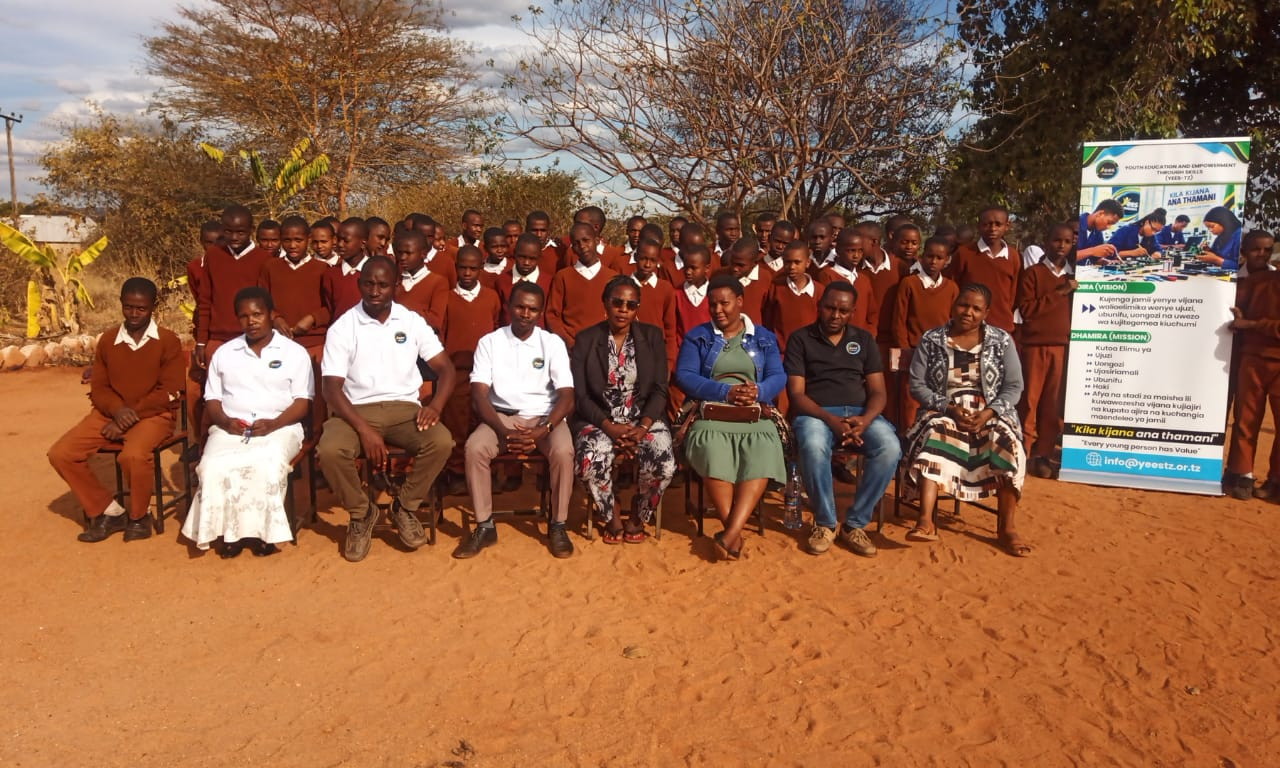 Group photograph from a YEES TZ activity with participants in school uniform and adult organizers.